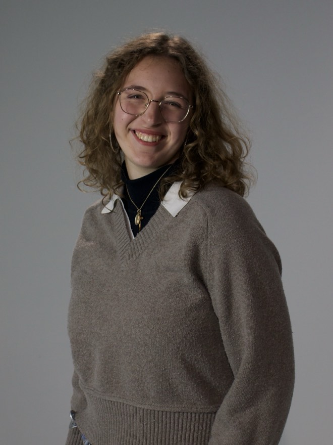 Mallory standing upright, smiling at the camera