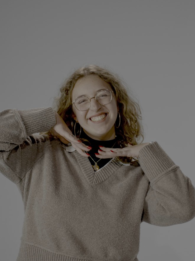 Mallory grinning with both hands framing her face